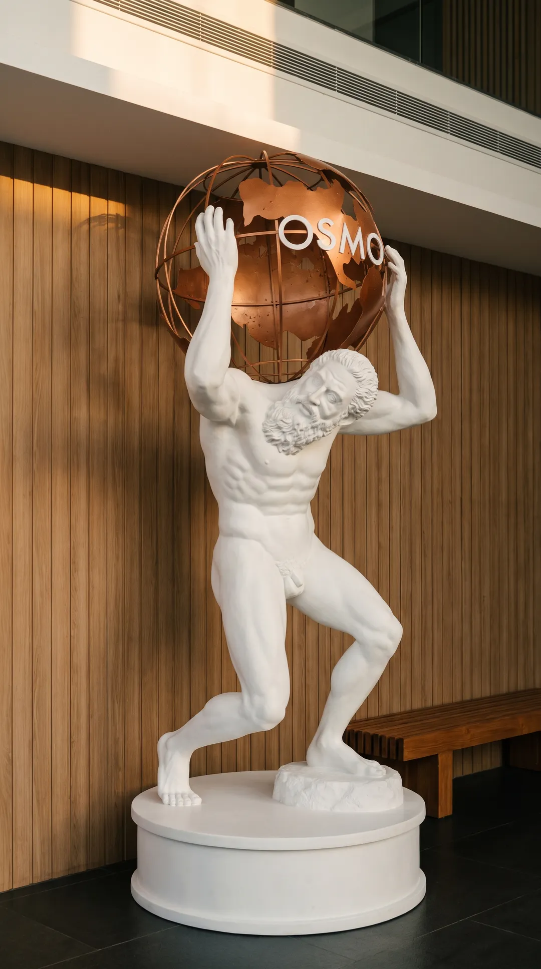 The white Atlas statue at OSMO, carrying a copper globe marked OSMO